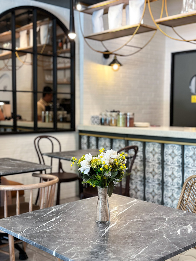 Bar area with brass fixtures and fresh floral arrangement